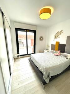 een slaapkamer met een bed en een groot raam bij Luxury and Modern Beach Apartment with Sea Views in La Mata