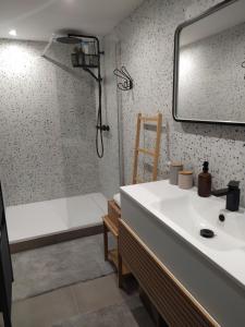 La salle de bains est pourvue d'un lavabo et d'une douche avec baignoire. dans l'établissement Charme et élégance au cœur d'un village provençal, à Pignans