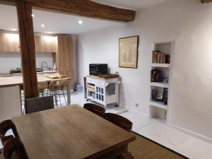 ein Esszimmer und eine Küche mit Tisch und Stühlen in der Unterkunft Charme et élégance au cœur d'un village provençal in Pignans