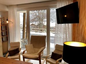 a living room with chairs and a large window at Aux pieds des pistes 4/6 personnes in Gérardmer