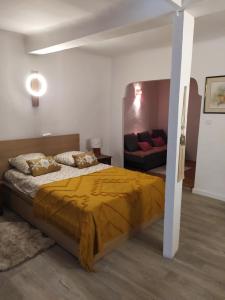 - une chambre avec un lit doté d'une couette jaune et d'un canapé dans l'établissement Charme et élégance au cœur d'un village provençal, à Pignans