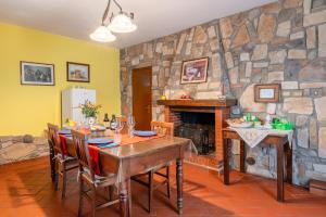 una sala da pranzo con tavolo e parete in pietra di La Bella Toscana Lemon Apartment a Monsummano