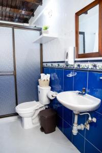 La salle de bains bleue et blanche est pourvue de toilettes et d'un lavabo. dans l'établissement Finca Villa Isanella, Santuario, Antioquia, à Santuario