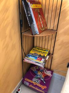 une étagère avec une pile de livres dans l'établissement Aux pieds des pistes 4/6 personnes, à Gérardmer