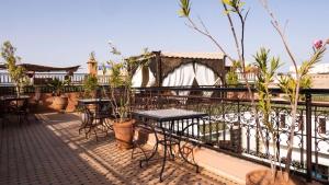 eine Terrasse mit Tischen und Stühlen auf dem Balkon in der Unterkunft Riad Afous in Marrakesch