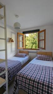 a bedroom with two beds and a window at Casa Calpurnia Cerler in Cerler