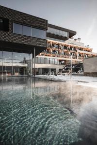 a building with a pool of water in front of a building at Santre dolomythic home in Bressanone