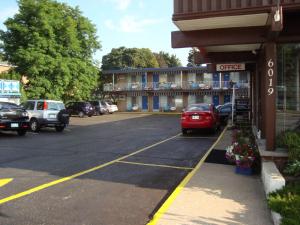 un estacionamiento con coches estacionados frente a un hotel en Advance Inn, en Niagara Falls