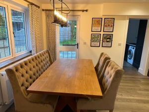 a dining room with a wooden table and chairs at Stylish Surrey Hills House 2 ensuite bedrooms in Ockley