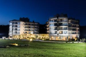 un gran edificio blanco por la noche con un campo verde en Azure Beach, en Punta del Este