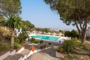 a swimming pool in a resort with trees and plants at Almarchada 38 in Mijas