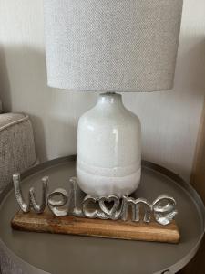 a table with a lamp and the word welcome on it at Modern, Spacious 2 bedroom caravan - Thorpe Park Haven, Cleethorpes in Cleethorpes