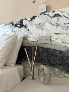 een slaapkamer met een wit bed en een marmeren muur bij Breccia Nel Mare in Carrara