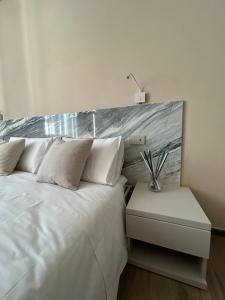 a bedroom with a white bed and a night stand at Breccia Nel Mare in Carrara