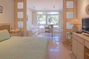 um quarto com uma cama e uma sala de estar em Oceana Suites en Green Park, playa Solanas em Punta del Este
