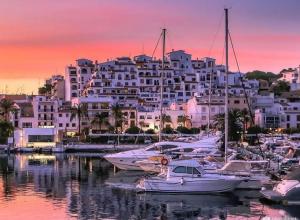 a group of boats in a marina with a large building at ATICO MORAIRA in Moraira
