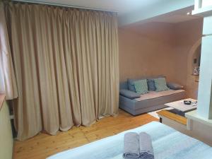a room with a bed and a couch and a window at Apartment Slađana in Subotica