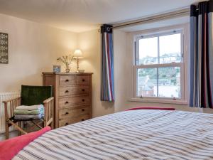 a bedroom with a bed and a window and a chair at 2 bed in Brixham 77769 in Brixham
