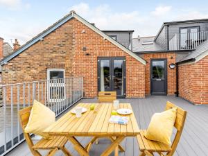 a patio with a wooden table and chairs on a balcony at 2 Bed in Brockenhurst 78728 in Brockenhurst