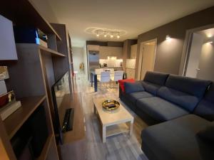 a living room with a blue couch and a table at Orquidia El Tarter in El Tarter