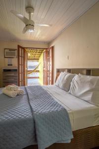 a bedroom with a large bed with towels on it at Pousada Cruzoé in Praia de Araçatiba