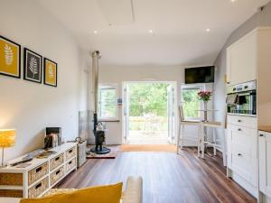 a kitchen and living room with white cabinets at 1 Bed in Dereham 78596 in Bawdeswell