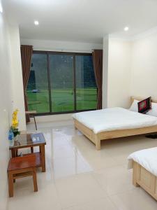 a bedroom with two beds and a large window at Homestay Hoà Thảo in Mù Cang Chải