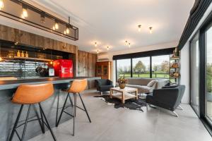 uma cozinha com um bar com cadeiras e um sofá em Rozeboom Loft em Aartrijke