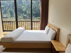 Bett in einem Zimmer mit einem großen Fenster in der Unterkunft Homestay Hoà Thảo in Mù Cang Chải