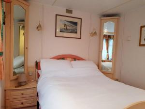 a bedroom with a white bed and a mirror at Green Shores in Weybourne