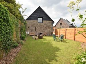 a garden with two chairs and a table in front of a building at 2 bed in Brecon 80519 in Llangorse