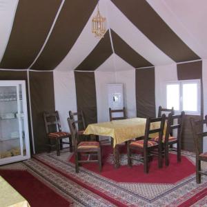 a dining room with a table and chairs in a tent at Bivouac Le Ciel Bleu in Erfoud