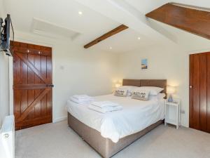 a bedroom with a large bed with a wooden door at 3 bed property in Exeter 82586 in Clyst Saint Mary