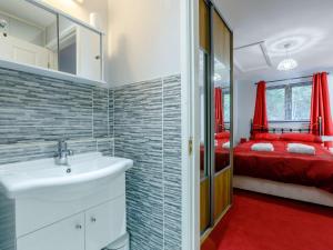 a bathroom with a sink and a red bedroom at 1 bed in Cinderford 82884 in Cinderford