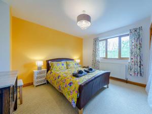 a bedroom with a bed with yellow walls and a window at 3 Bed in Brecon 83076 in Aber-Brân