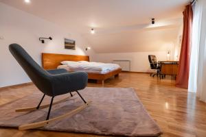 - une chambre avec un lit et une chaise sur un tapis dans l'établissement La Moldo, à Moldoviţa