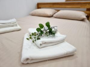 two beds with white towels with a flower arrangement on them at La Casuță in Dej