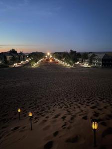 a beach with lights in the sand at night at Bivouac Le Ciel Bleu in Erfoud