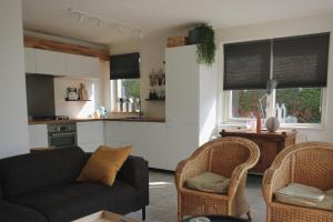 a living room with a couch and two chairs at Hello Zeeland - Vakantiehuis Schelde 148 in Breskens