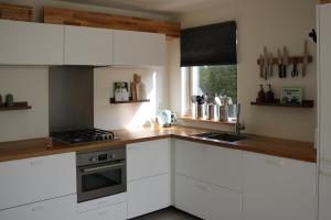 a kitchen with white cabinets and a counter top at Hello Zeeland - Vakantiehuis Schelde 148 in Breskens