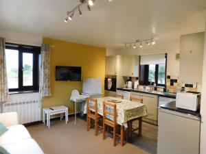 een keuken met een tafel en stoelen in een kamer bij Paddock Bungalow in Mundesley