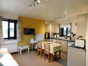 a kitchen with a table and chairs in a room at Paddock Bungalow in Mundesley