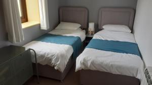 two twin beds in a room with a window at Paddock Bungalow in Mundesley
