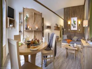 a dining room and living room with a table and a couch at Residence & Spa Les Chalets de Solaise in Val-d'Isère