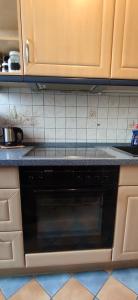 a black dishwasher in a kitchen with wooden cabinets at Komfortables und sauberes Zimmer in Leipzig