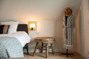 1 dormitorio con cama y taburete de madera en Rozeboom Loft, en Aartrijke