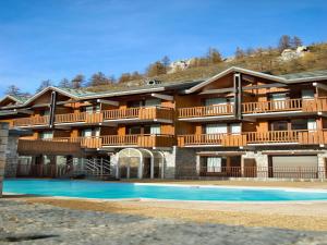 a large building with a swimming pool in front of it at Residence & Spa Les Chalets de Solaise in Val-d'Isère