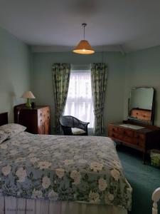 une chambre avec un lit, une commode et un miroir dans l'établissement Old Schoolyard Cottage, à Sheringham