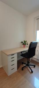 um escritório com uma secretária com uma cadeira e uma planta em Komfortables und sauberes Zimmer em Leipzig