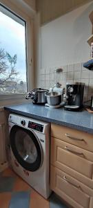 a kitchen with a washing machine with pots and pans at Komfortables und sauberes Zimmer in Leipzig